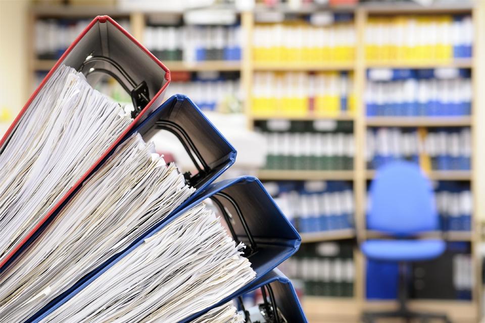 Reports Stack of binders in front of bookshelves