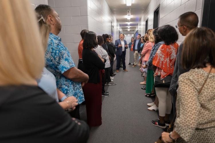 Group standing in hallway of the Opportunity Center with Henry Gonzales, Executive Director, Harris County Juvenile Probation, speaking